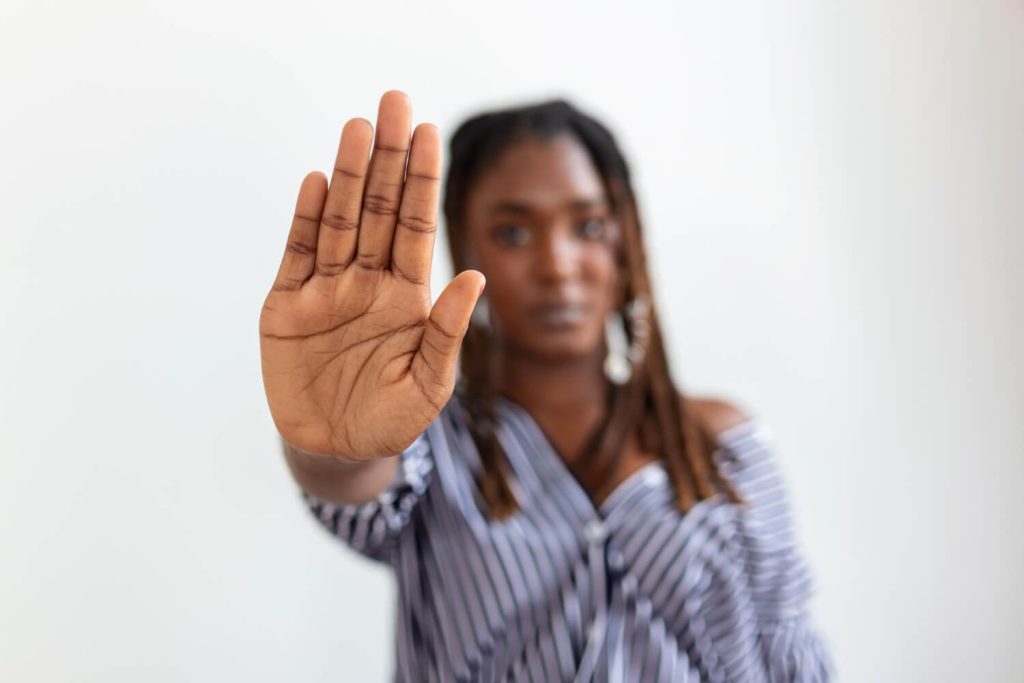 Black woman raising her hand and saying no to everything she likes due to burnout