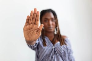 Black woman raising her hand and saying no to everything she likes due to burnout and overwhelm paralysis