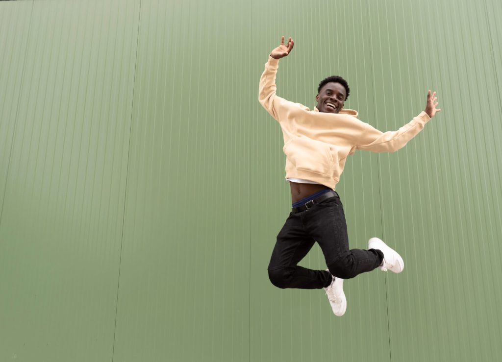 young black man jumping to reduce his cortisol levels and minimise stress