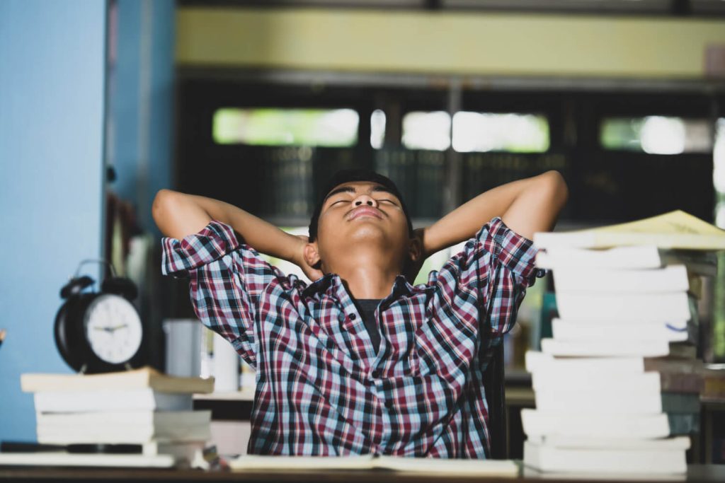 tired student in library used to depict relationship between sleep and productivity