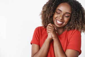 Caring and loving gentle african-american girlfriend showing gratitude for romantic boyfriend close eyes and smiling broadly pressing hands together happily