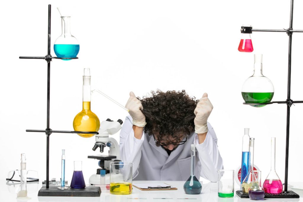 A lab technician exhausted and putting his head down while investigating the science behind attention residue