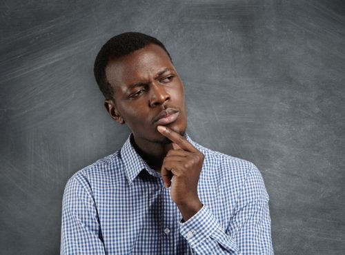 A black young man with his hand under his chin to depict decision-making strategies to help you make better decisions