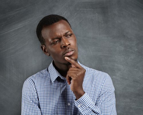 A black young man with his hand under his chin to depict decision-making strategies to help you make better decisions